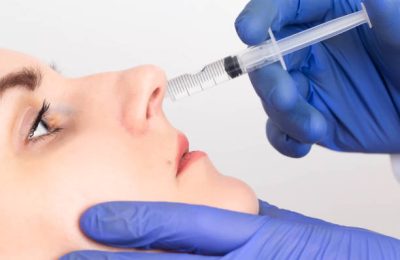 The doctor makes the procedure to the girl patient an intranasal block, close-up. Treatment concept for dry and burning nose, endonasal